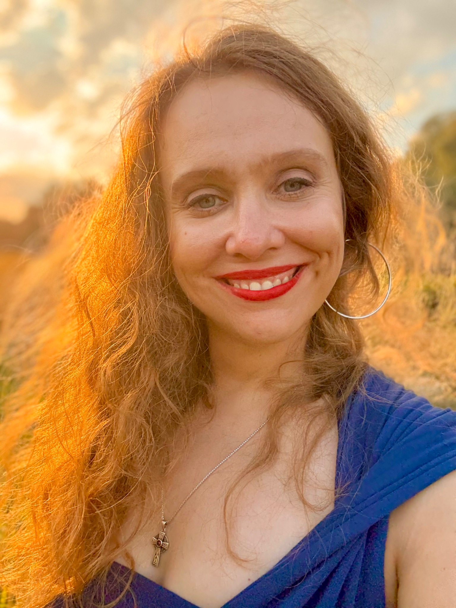 Anna Piechowska smiling outdoors in warm evening light